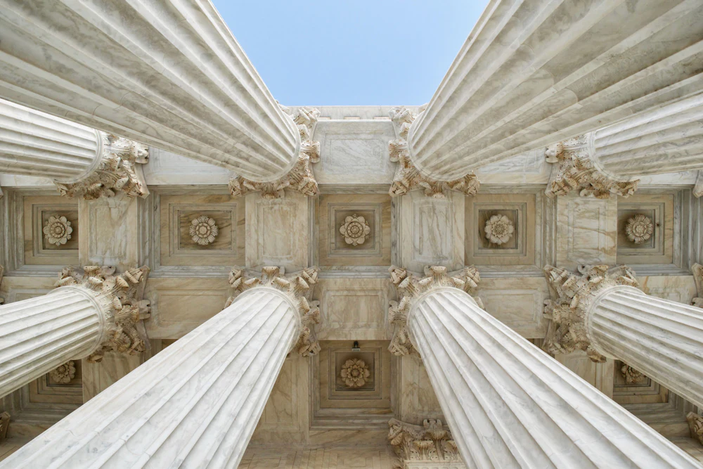 Fluted stone columns and carved capitals of a classical courthouse portico.
